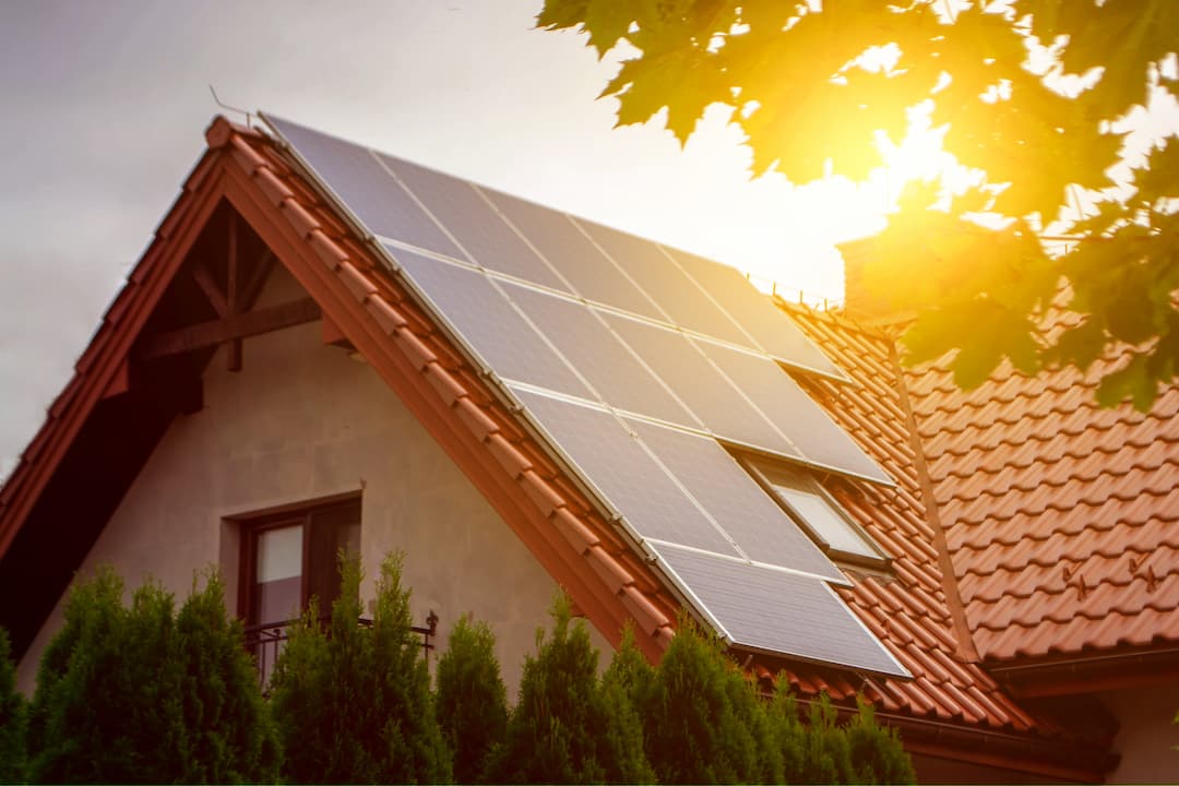 House with solar panels at sunset showing benefits of solar energy