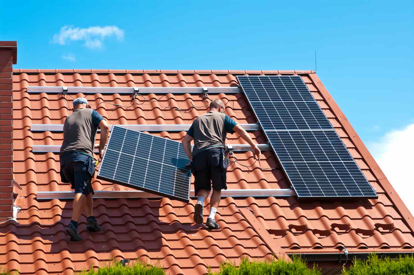 People installing solar panels on a house roof to offset Perth power price increase